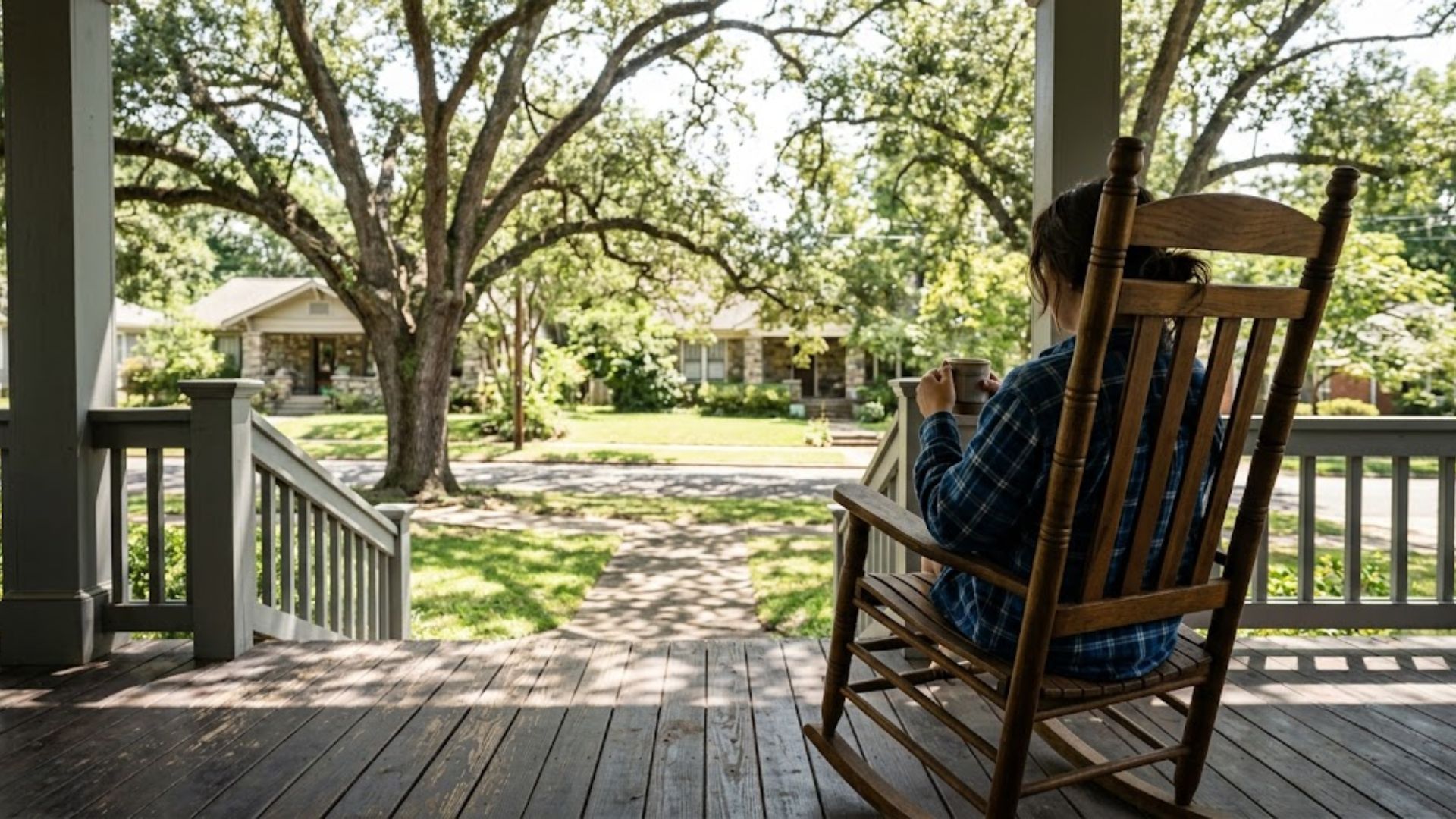 A craftsman porch shaded by Southern oaks at midday.